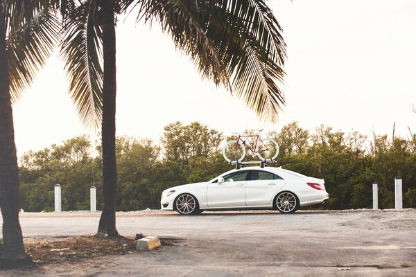 Mercedes blanco con Maletero en el que se fija la bicicleta