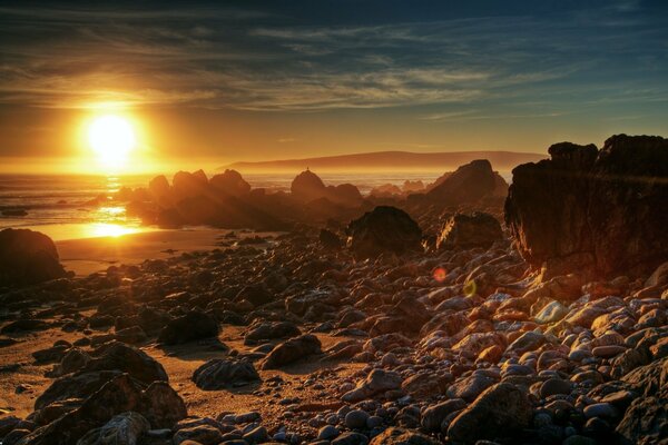 Pietre in riva al mare e tramonto