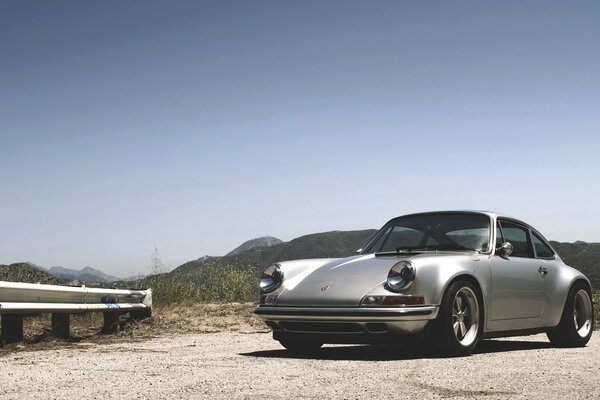 Porsche im Hintergrund von Bergen und Sand