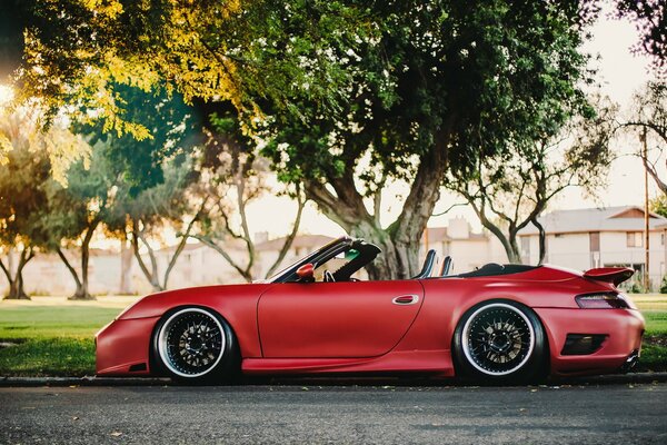 Rotes Porsche Cabrio Auto und grüne Bäume