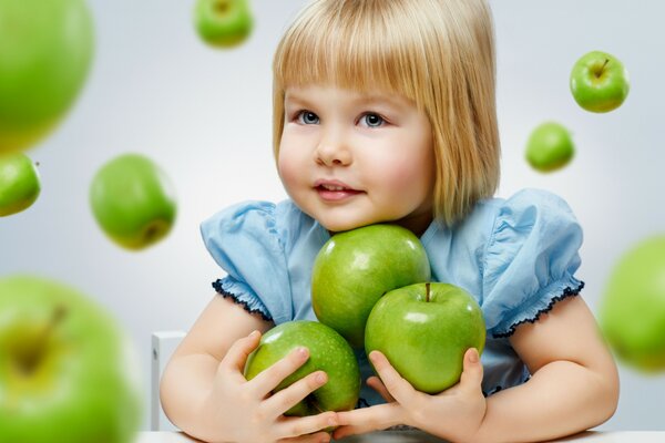 Modèle de petite fille avec des pommes vertes