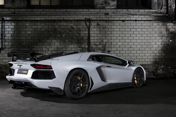 Voiture de sport tuning blanc lamborghini sur fond de mur