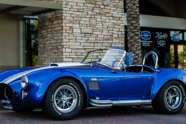 Blue Shelby Cobra near the building