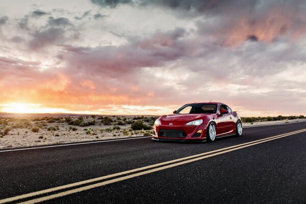 Toyota sportiva rossa sullo sfondo del tramonto