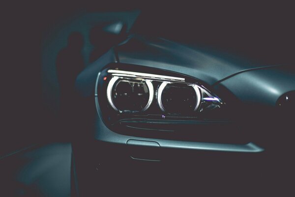 BMW car on a dark background with a view of the front headlight