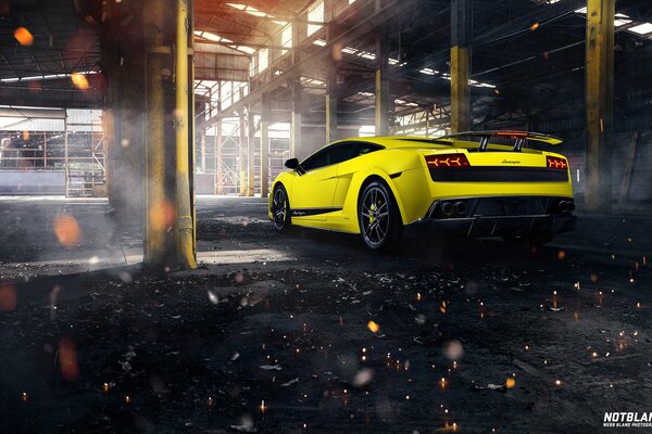 Gelber Lamborghini verlässt eine große Fabrik