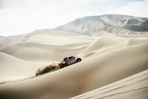 Off-road vehicle among the sand dunes on Dakar