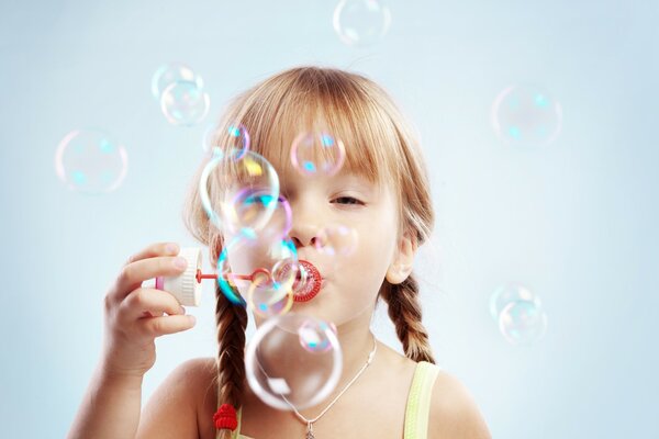 Fille avec des nattes fait des bulles