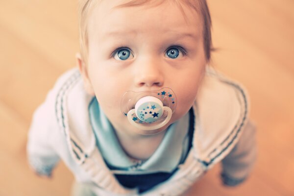 Bebé con ojos azules y hermosos chupa chupete