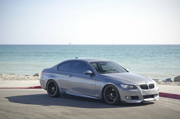 Graues Coupé BMW 335i Schatten Strand Meer