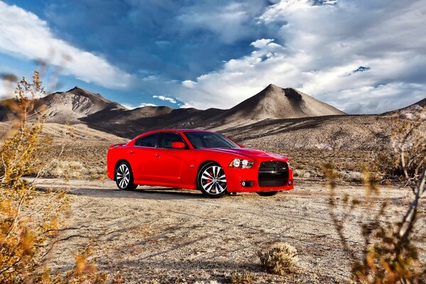 Red sedan on the background of mountains and sky