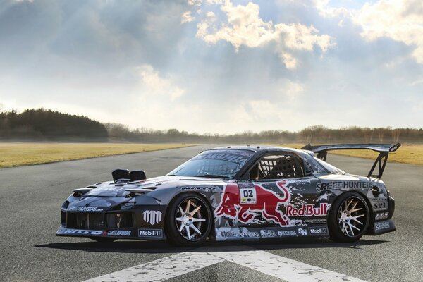 Mazda with a red bull on the background of nature