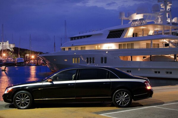 A car on the coast against the background of a yacht