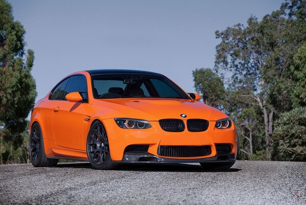 Orange BMW behind the trees