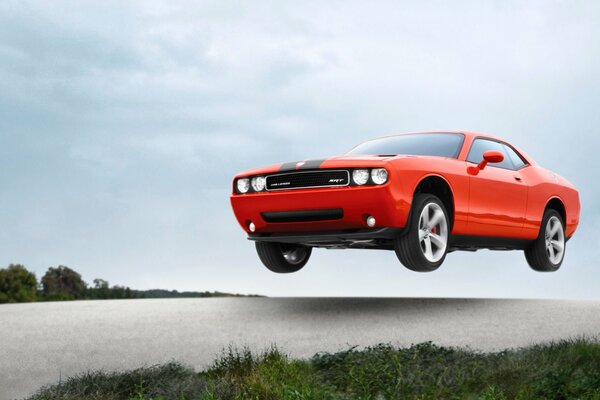 Challenger srt8 orange dans les airs à grande vitesse