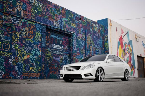 Mercedes blanco, graffiti en la pared