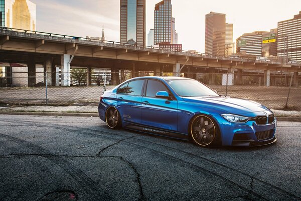 BMW 335i azul en el fondo de la ciudad