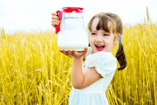 Chica en el campo con una jarra de leche