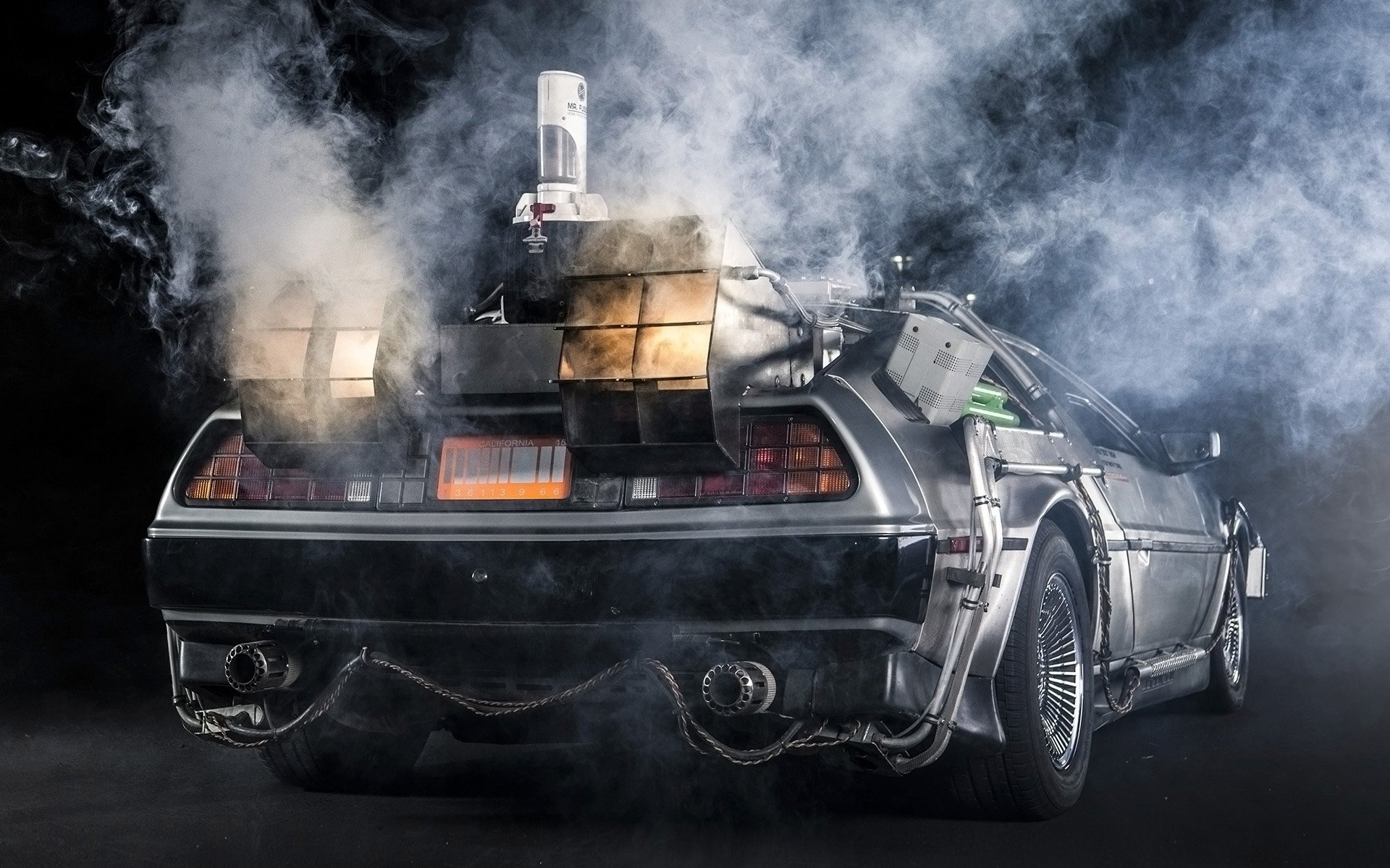 delorean dmc-12 retour vers le futur machine à remonter le temps delorean vue arrière fumée échappement arrière-plan