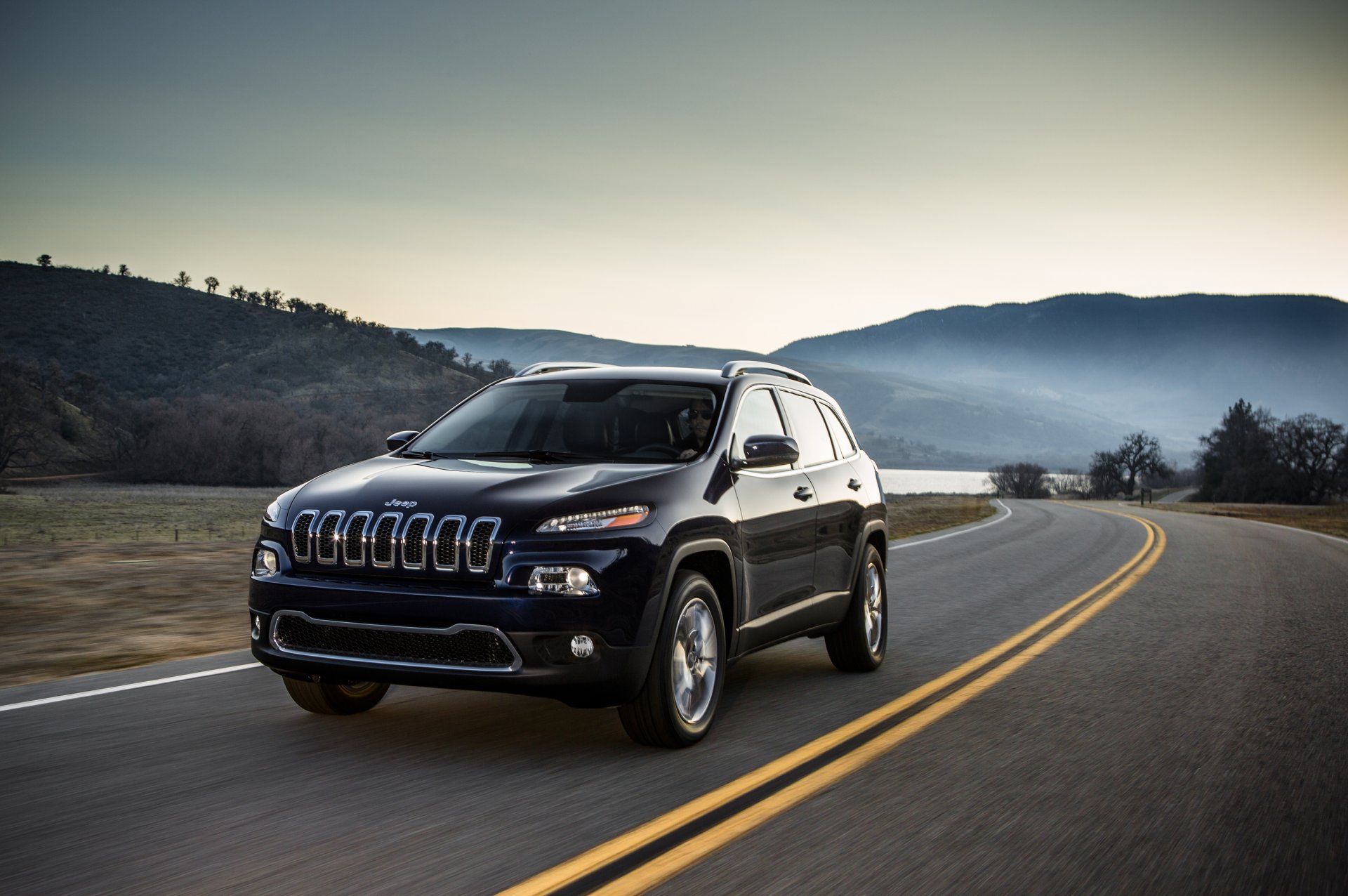 carretera marcado coche jeep cherokee. suv colinas árboles
