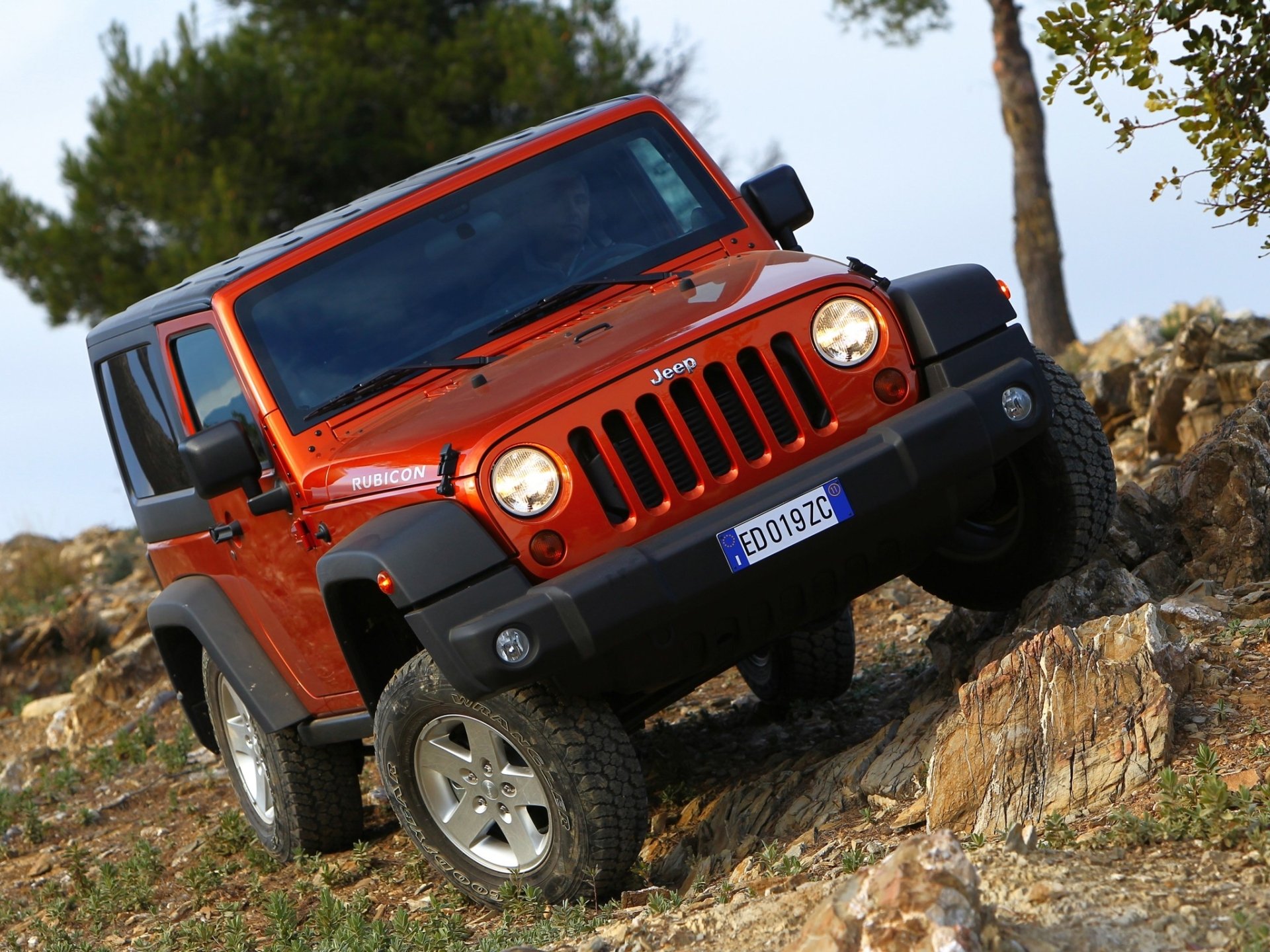 jeep wrangler rangler rubicon red front end suv off road rocks slope tree