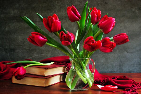 Un ramo de Tulipanes en un jarrón cerca de un libro