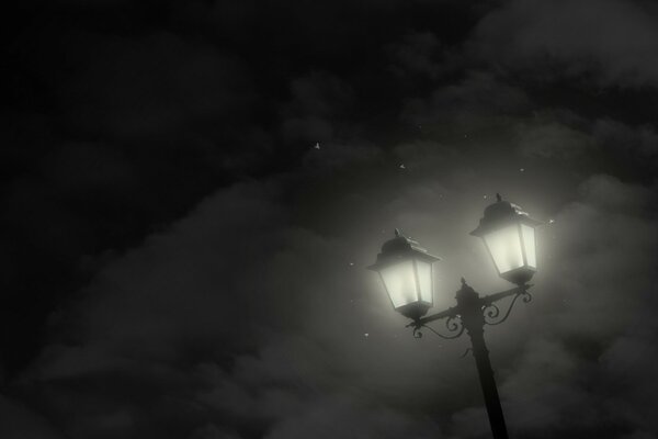 The light of the lanterns illuminates the foggy street