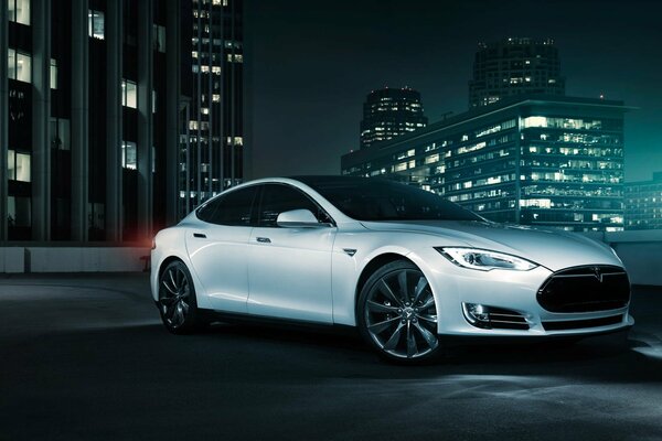 White Tesla electric car on the city landscape