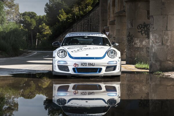 La Porsche bianca si riflette nello specchio d acqua liscio