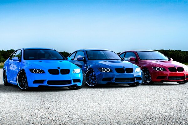 Der rote, blaue und blaue BMW ist auf dem Ödland abgestellt
