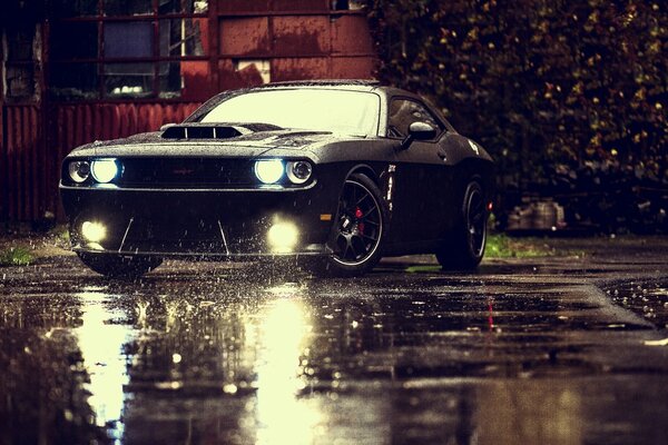 Black-colored car with headlights on