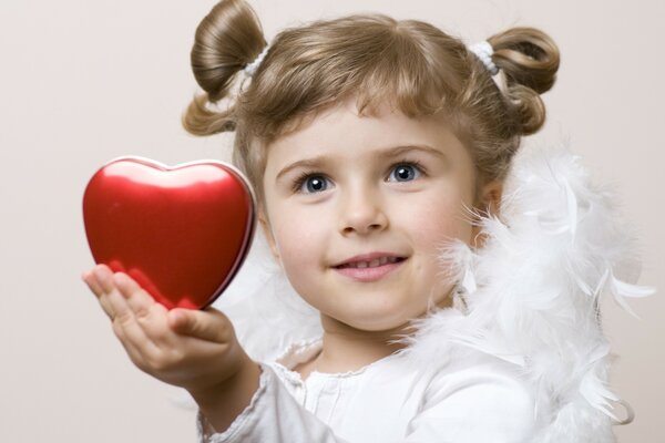 Niña extiende su corazón en su mano