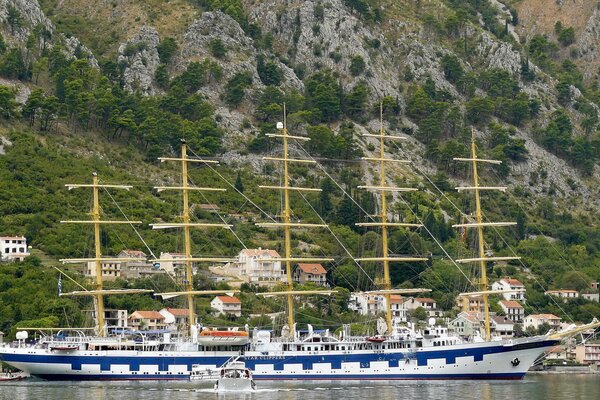 Un enorme barco se encuentra en la orilla frente a las montañas