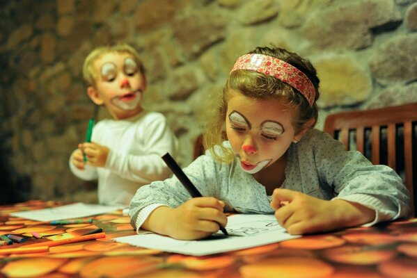Niña y niño pintan con rotuladores