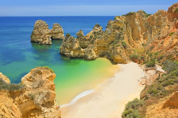Hermosa playa junto al mar rodeada de acantilados