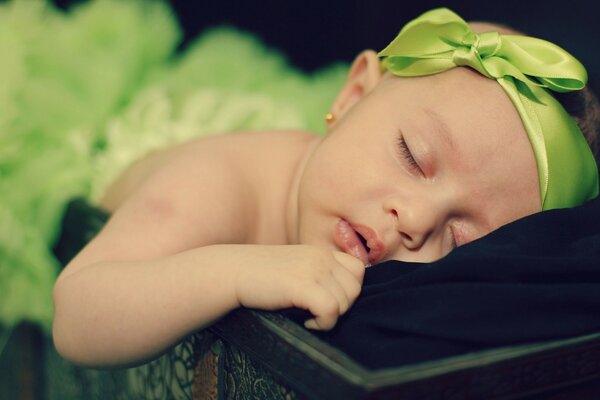 The child with the green ribbon is sleeping
