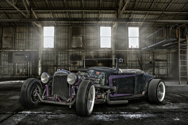 An old car on the background of a hangar