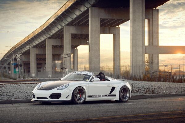 Porsche boxster кабриолет на фоне моста и заката