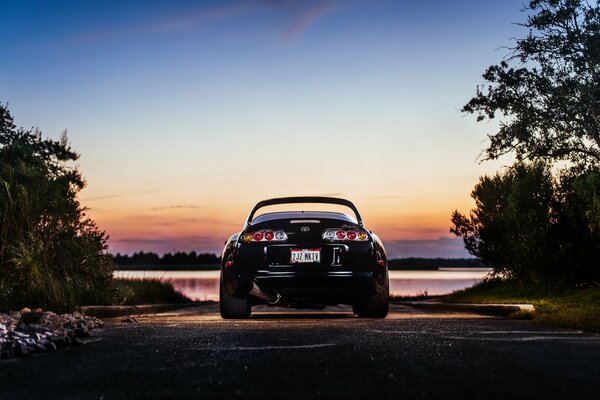 Toyota au coucher du soleil près du lac