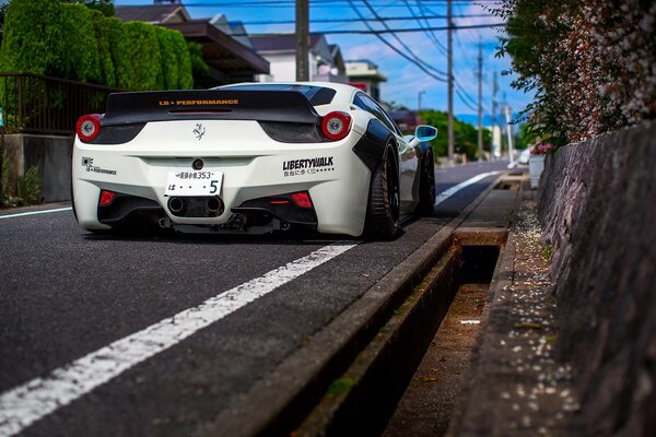 A beautiful white car is driving along the road