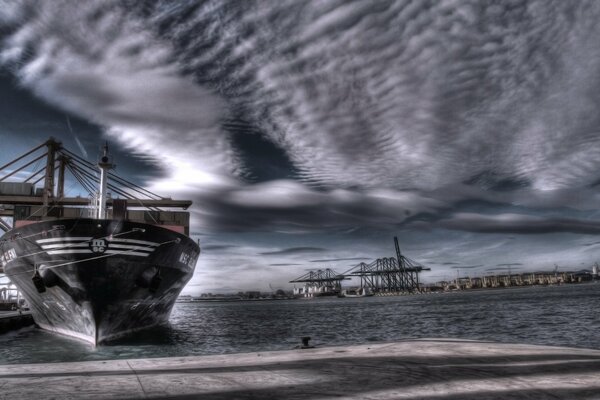 Schiff im Seehafen und Gewitterwolken