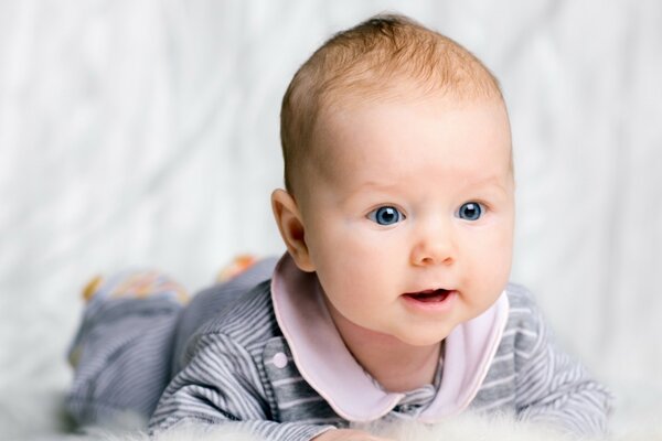 Baby boy dagli occhi azzurri in pigiama a righe