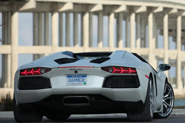 Ein neuer weißer Lamborghini steht vor dem Gebäude