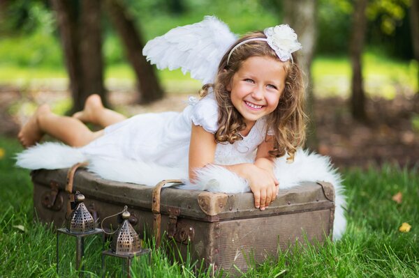 A joyful girl on a suitcase with wings