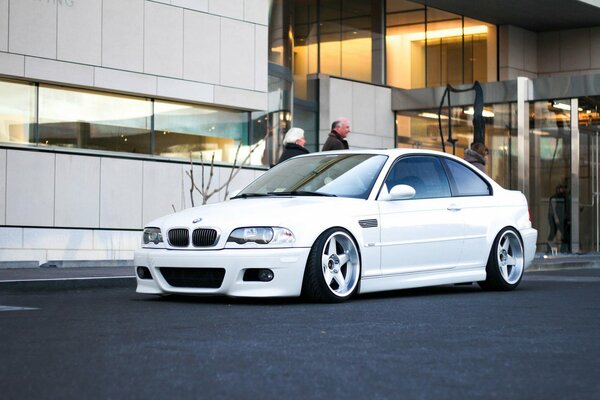 A tuned white BMW car with beautiful wheels