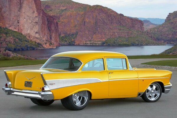 Retro car yellow Chevrolet on lake background