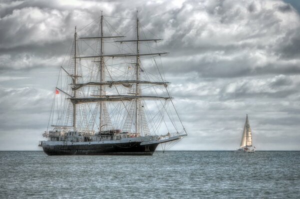 Schiff ist eine Kunst. Es sieht sehr schön am Horizont des grauen Himmels und der geräumigen Oberfläche des Ozeans aus