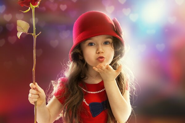 Un niño con ropa roja y una rosa en la mano