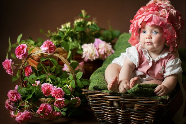 Lustiges Babyfoto mit Blumen und Korb