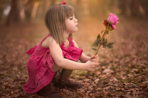 Una niña con una rosa y un paisaje de otoño